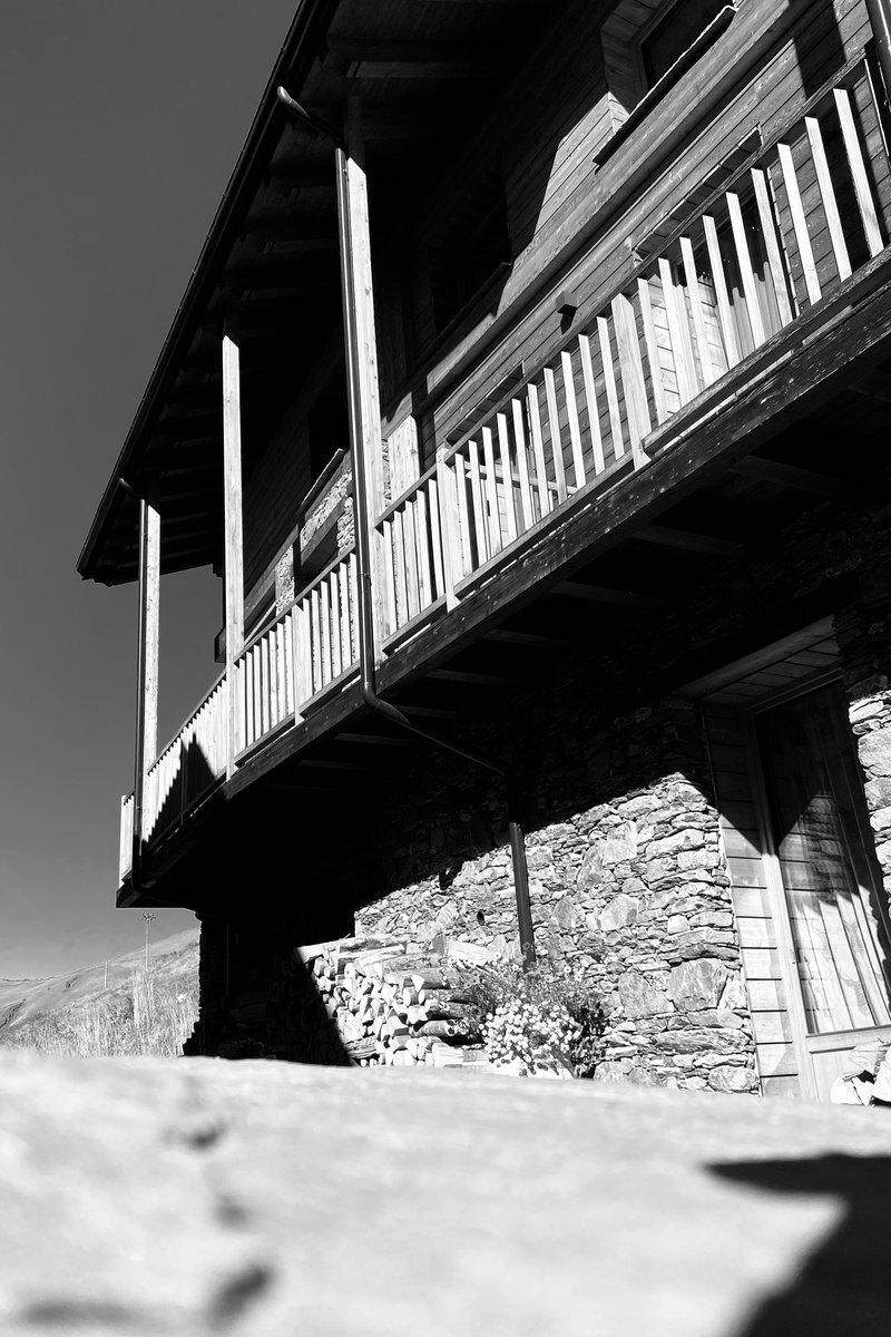 Balconata in legno tradizionale su casa in pietra